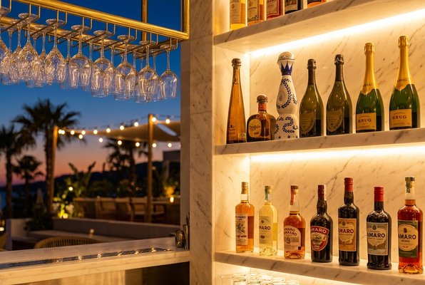 Premium spirits and bar glassware lit from behind at the SÉLAS bar Premium spirits and bar glassware lit from behind at the SÉLAS bar