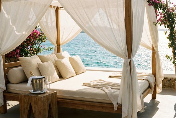 Close view of a private cabana with cream cushions and the shimmering sea beyond Close view of a private cabana with cream cushions and the shimmering sea beyond